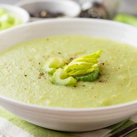 celery soup in a bowl with celery on top