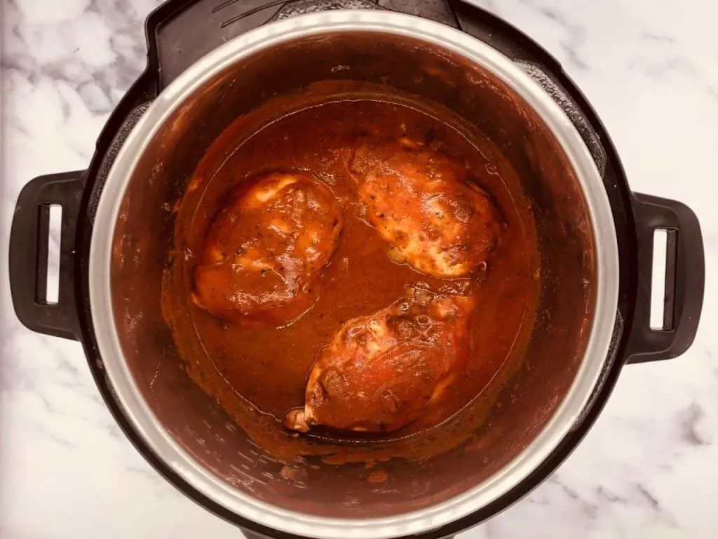 adding passata and chicken stock to Chicken Tikka Masala