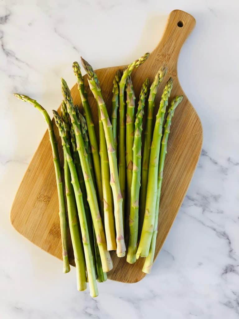 raw asparagus on a chopping board