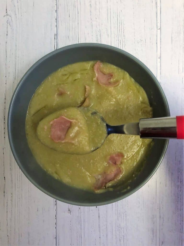 ham and pea soup in a bowl with a spoon