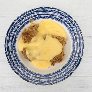 apple crumble in bowl with custard
