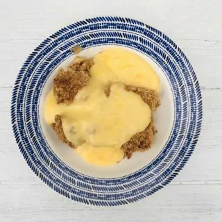 apple crumble in bowl with custard