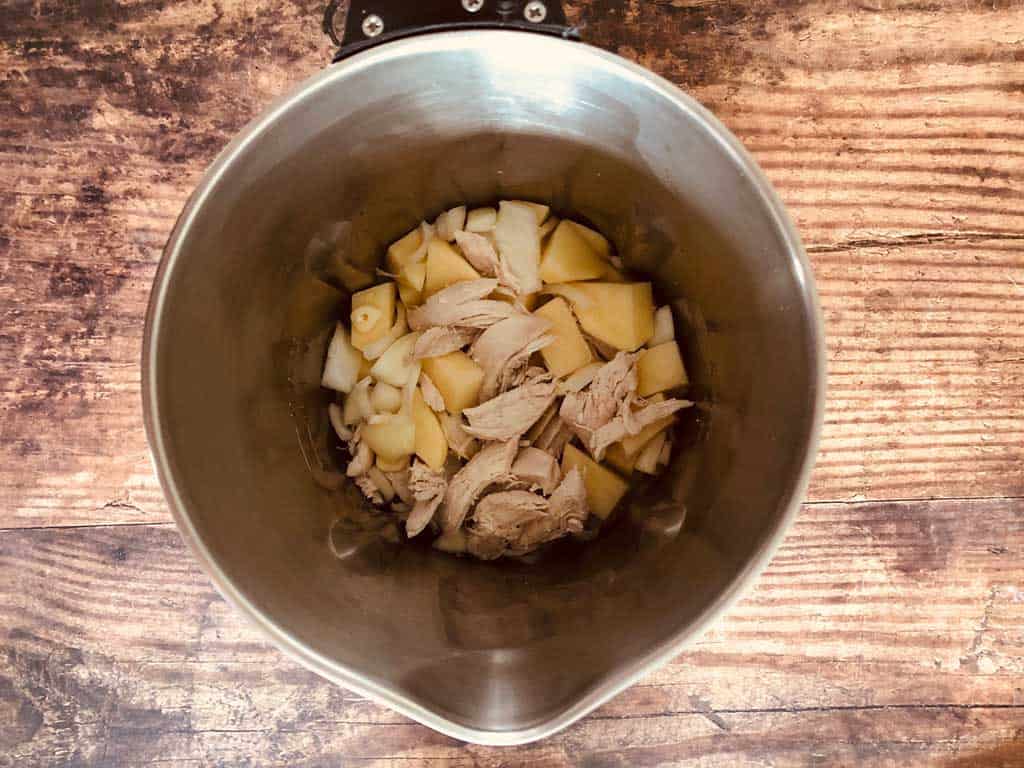 ingredients in soup maker for chicken soup, chicken, potato, onion and garlic chopped up