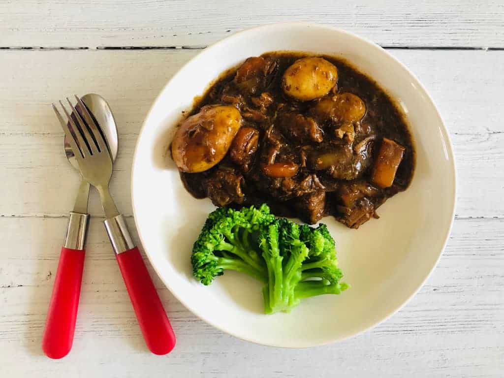 beef casserole on a plate with broccoli