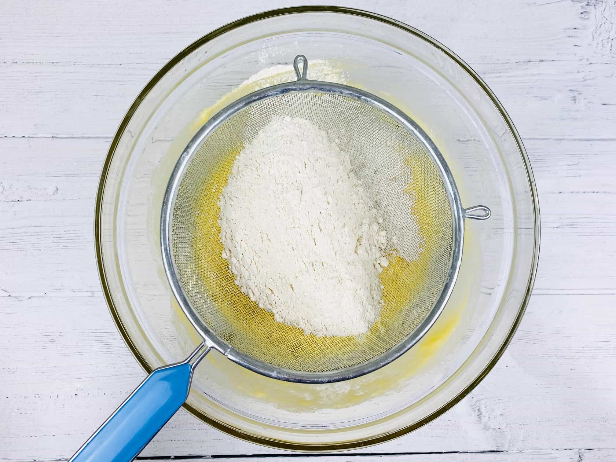 sifting flour into lemon drizzle cake mixture