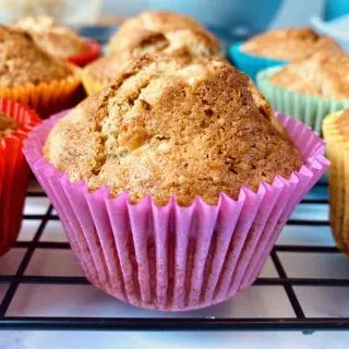 close up of banana muffin in pink case among other muffins
