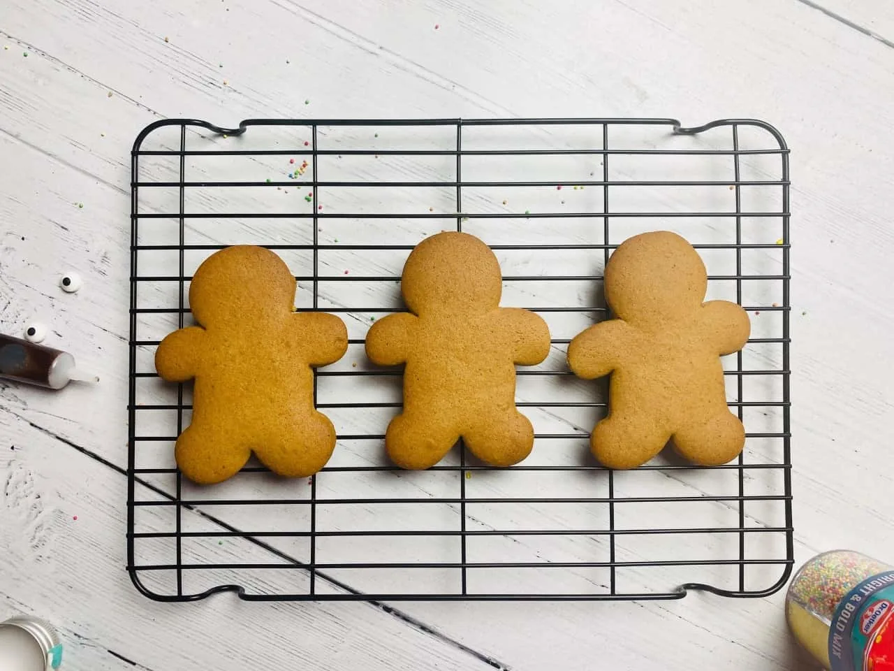 3 plain gingerbread men cooling down on a wire rack ready to be decorated