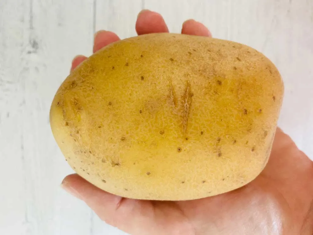 potato in hand for making jacket potato