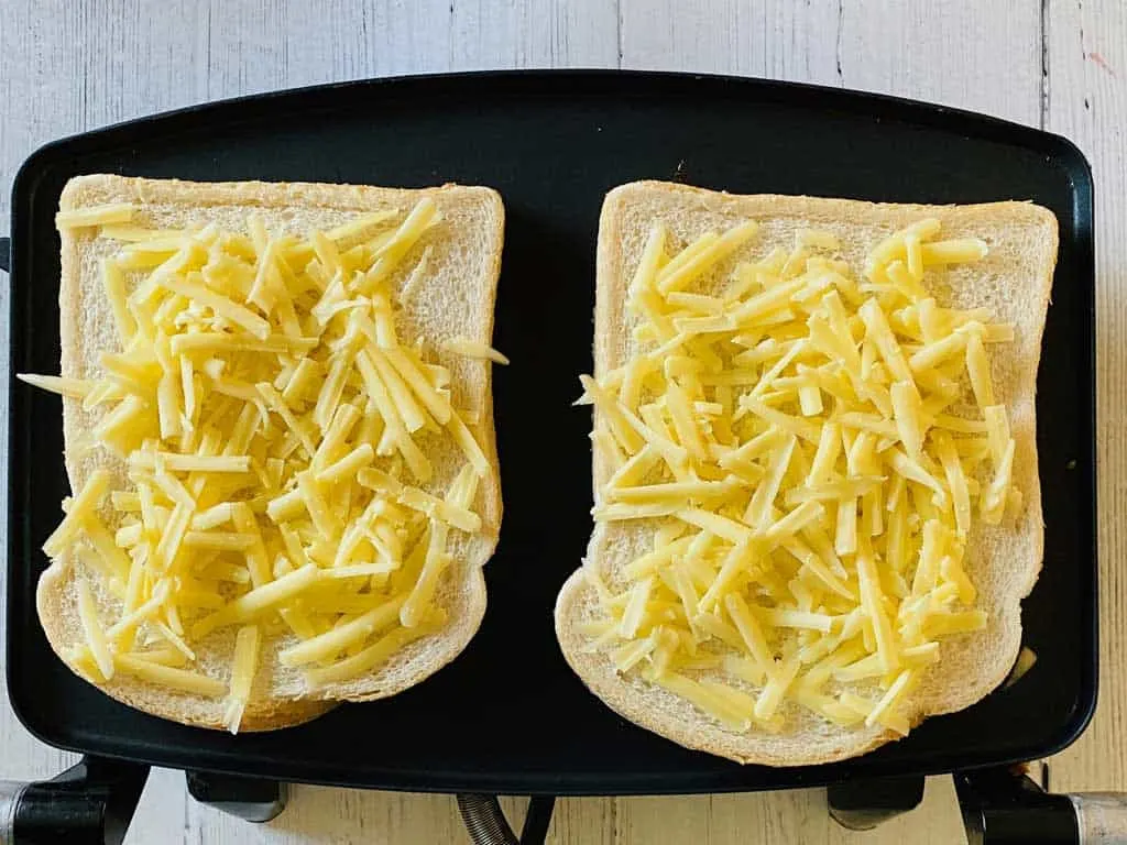 grated cheese on bread for ham and cheese toastie