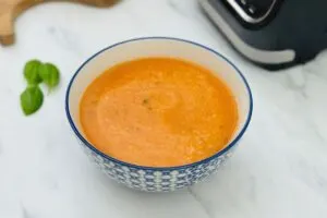 tomato soup next to soup maker