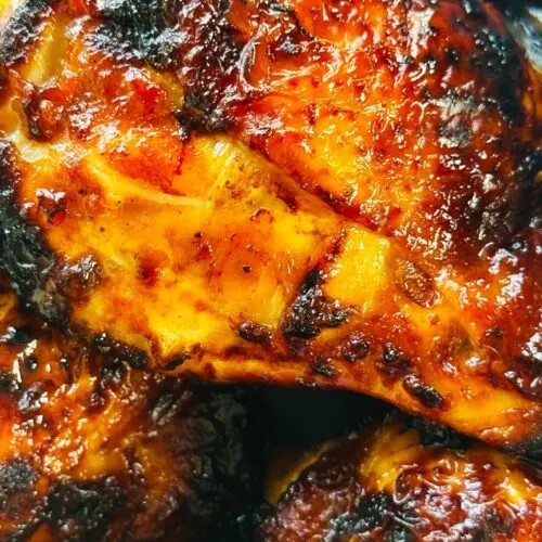 close up of air fried chicken thighs with skin on cooked in harissa and honey