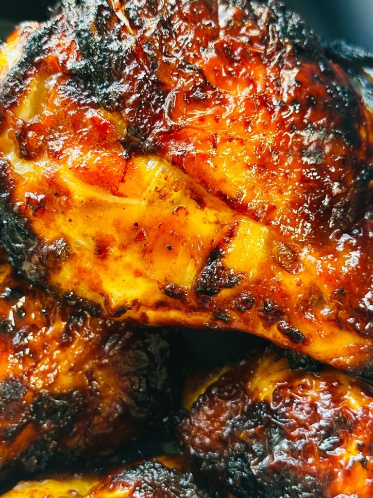 close up of air fried chicken thighs with skin on cooked in harissa and honey