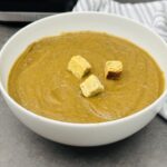 black bean and sweet potato soup with croutons in a bowl next to Ninja soup maker