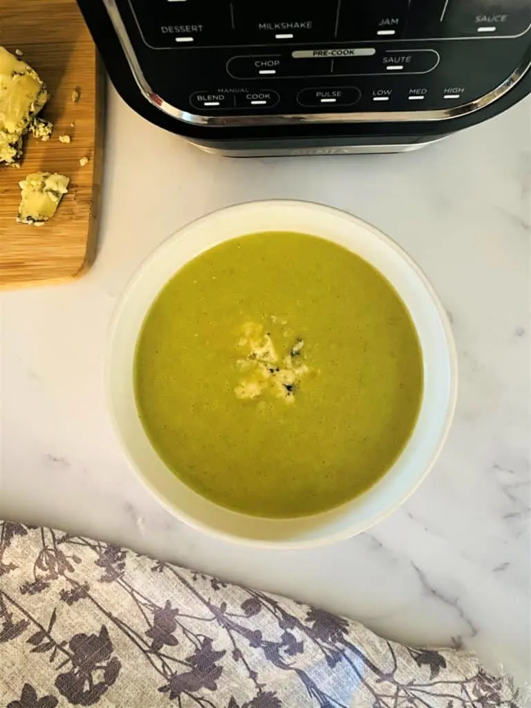 Broccoli and Stilton Soup in a bowl next to the Ninja Soup Maker