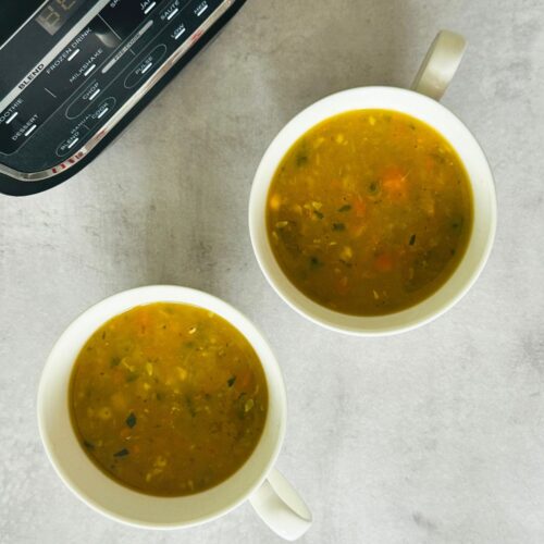 Chunky Vegetable Soup in two soup mugs next to a Ninja soup maker
