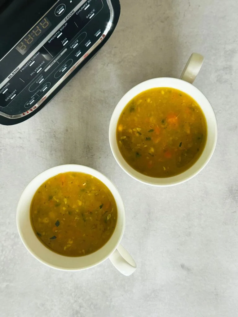 Chunky Vegetable Soup in two soup mugs next to a Ninja soup maker