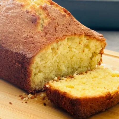 coconut loaf cake on a chopping board close up, sliced