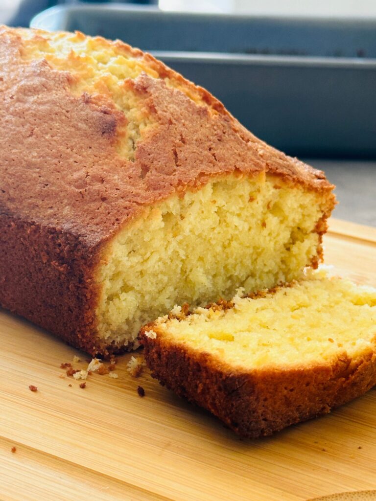 coconut loaf cake on a chopping board close up, sliced