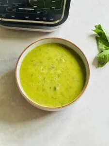 courgette and basil soup next to a Ninja soup maker