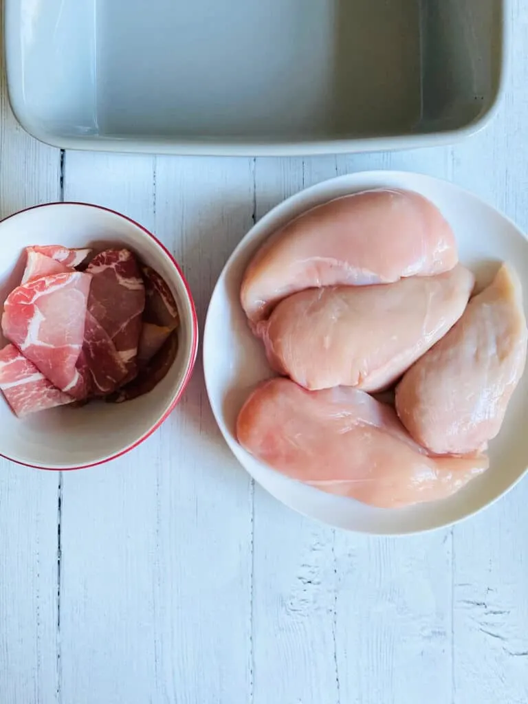 4 chicken breasts and bacon rashers next to oven dish ready to make hunter's chicken