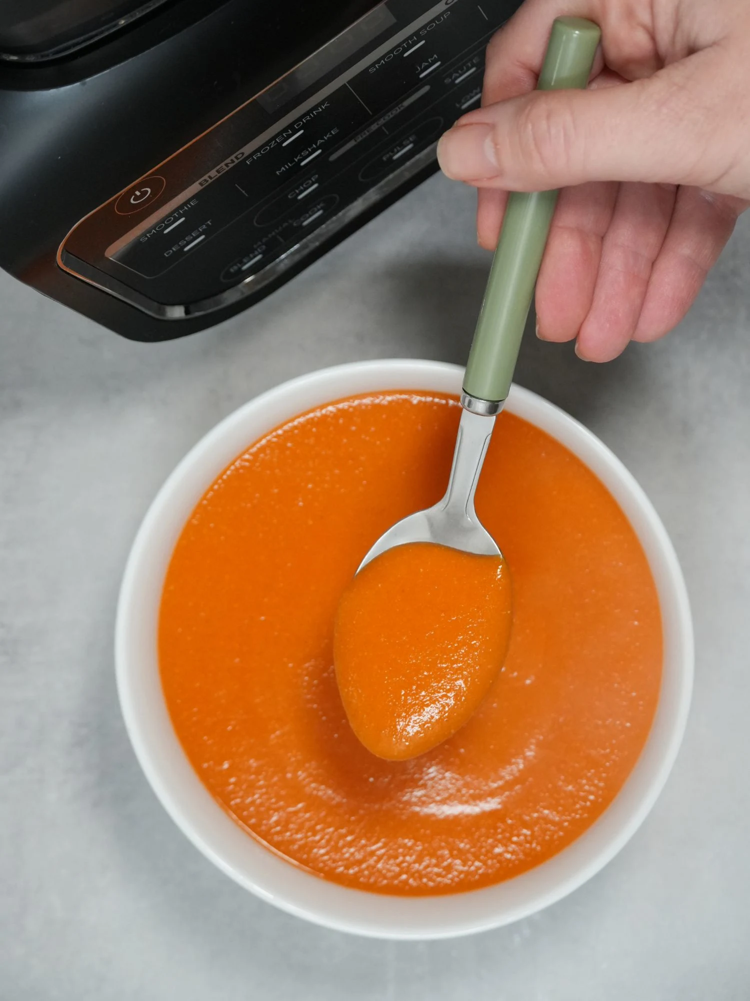 tomato red lentil and chickpea soup in a bowl with a spoon