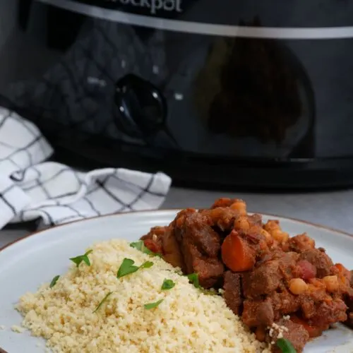 Moroccan style beef stew next to some cous cous in front of a slow cooker