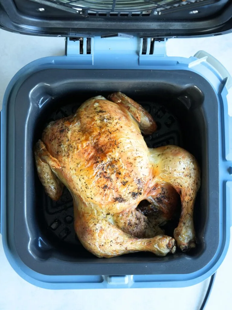 cooked whole roast chicken in a Ninja Speedi with a lid open