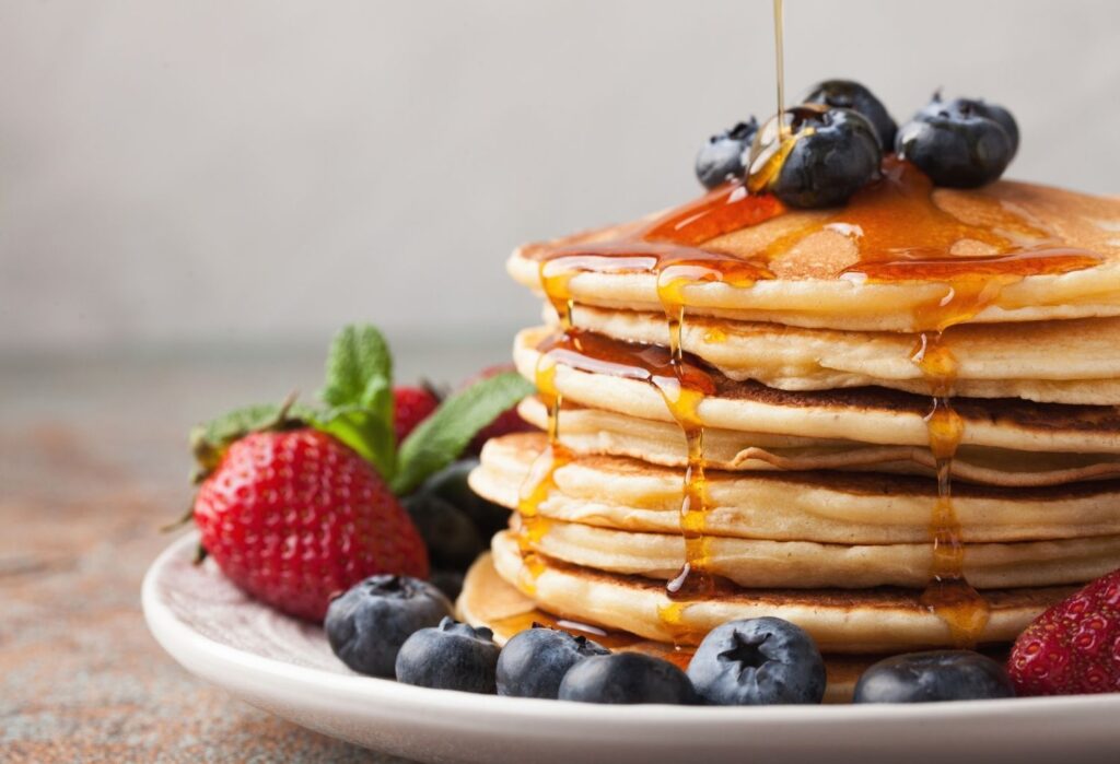 pancakes with maple syrup, blueberries and strawberries
