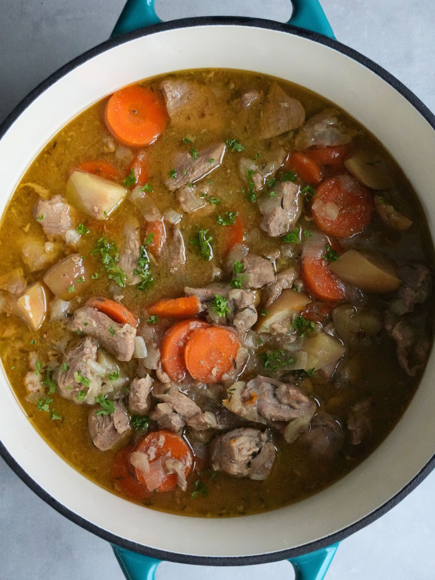 pork apple and cider casserole in a dutch oven casserole dish