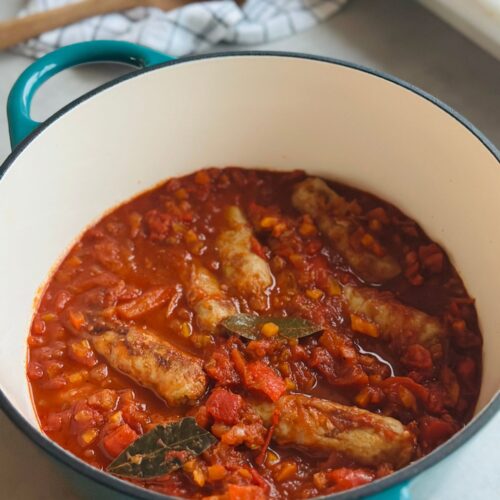 sausage casserole in a turquoise coloured Dutch oven