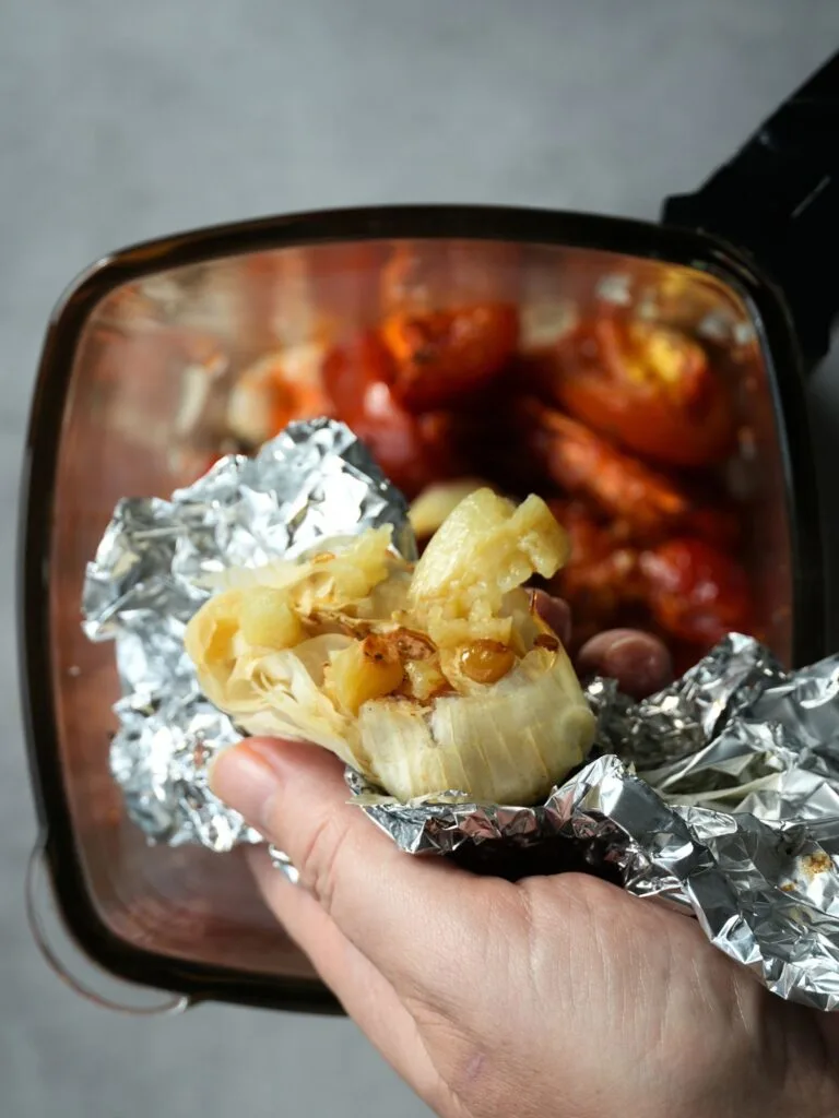 squeezing roasted garlic out of a whole roasted garlic bulb