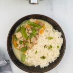 thai green curry with rice in a bowl next to a Ninja Foodi 15 in 1 multicooker