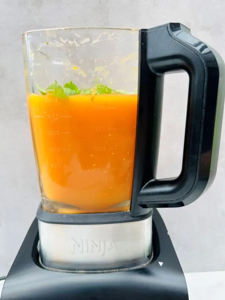 adding basil to tomato soup in soup maker