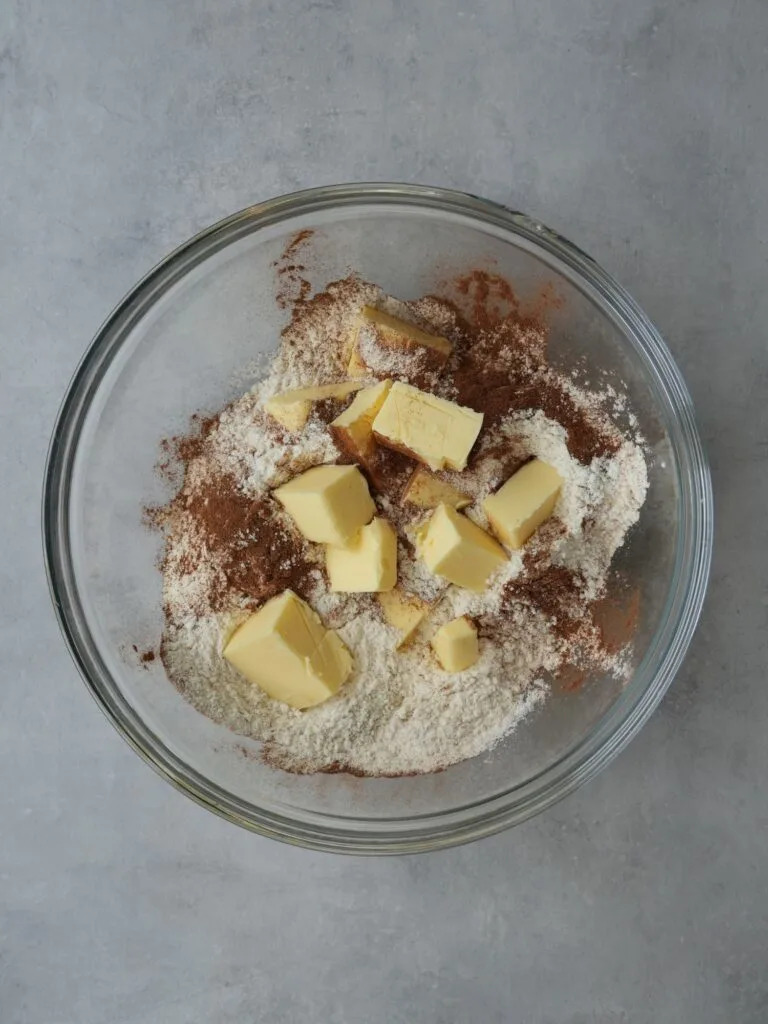 large mixing bowl with cubed butter, flour and ground cinnamon