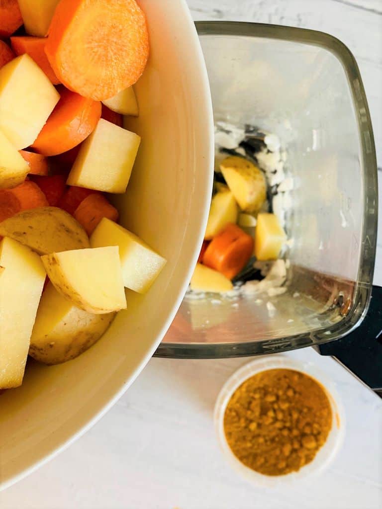 adding chopped carrots and potatoes to soup maker