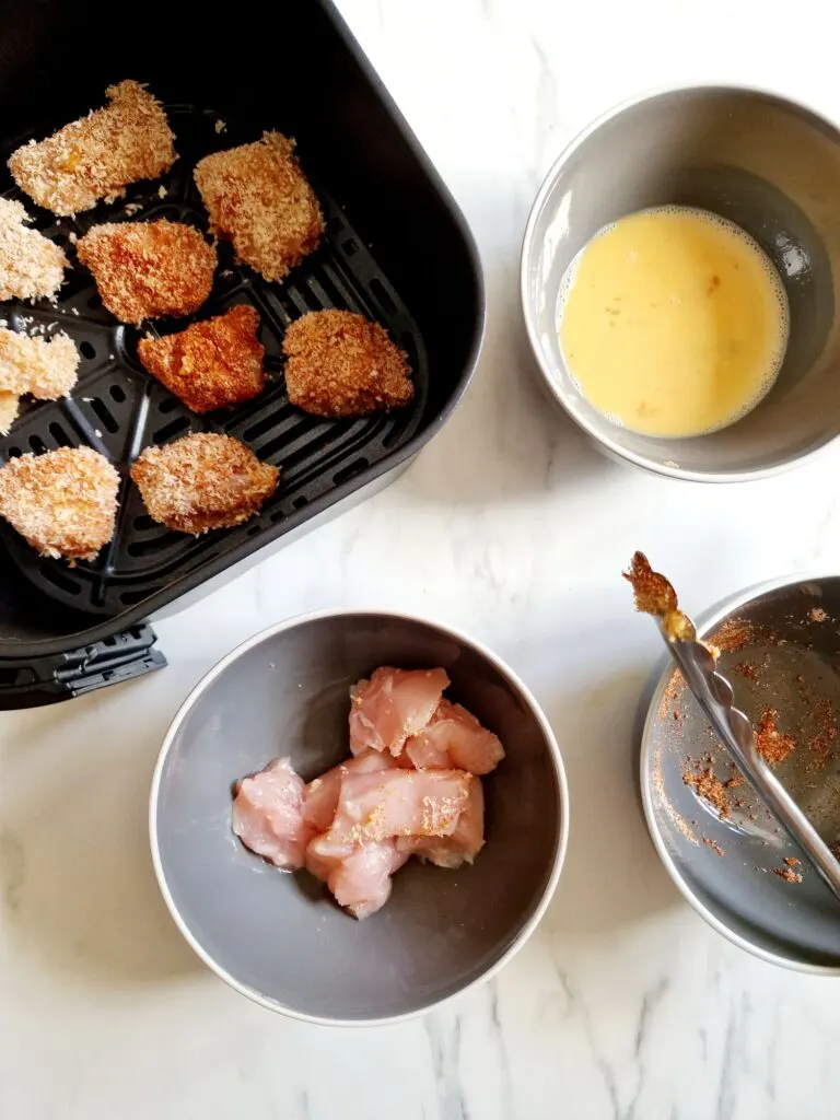 adding chicken nuggets to air fryer basket