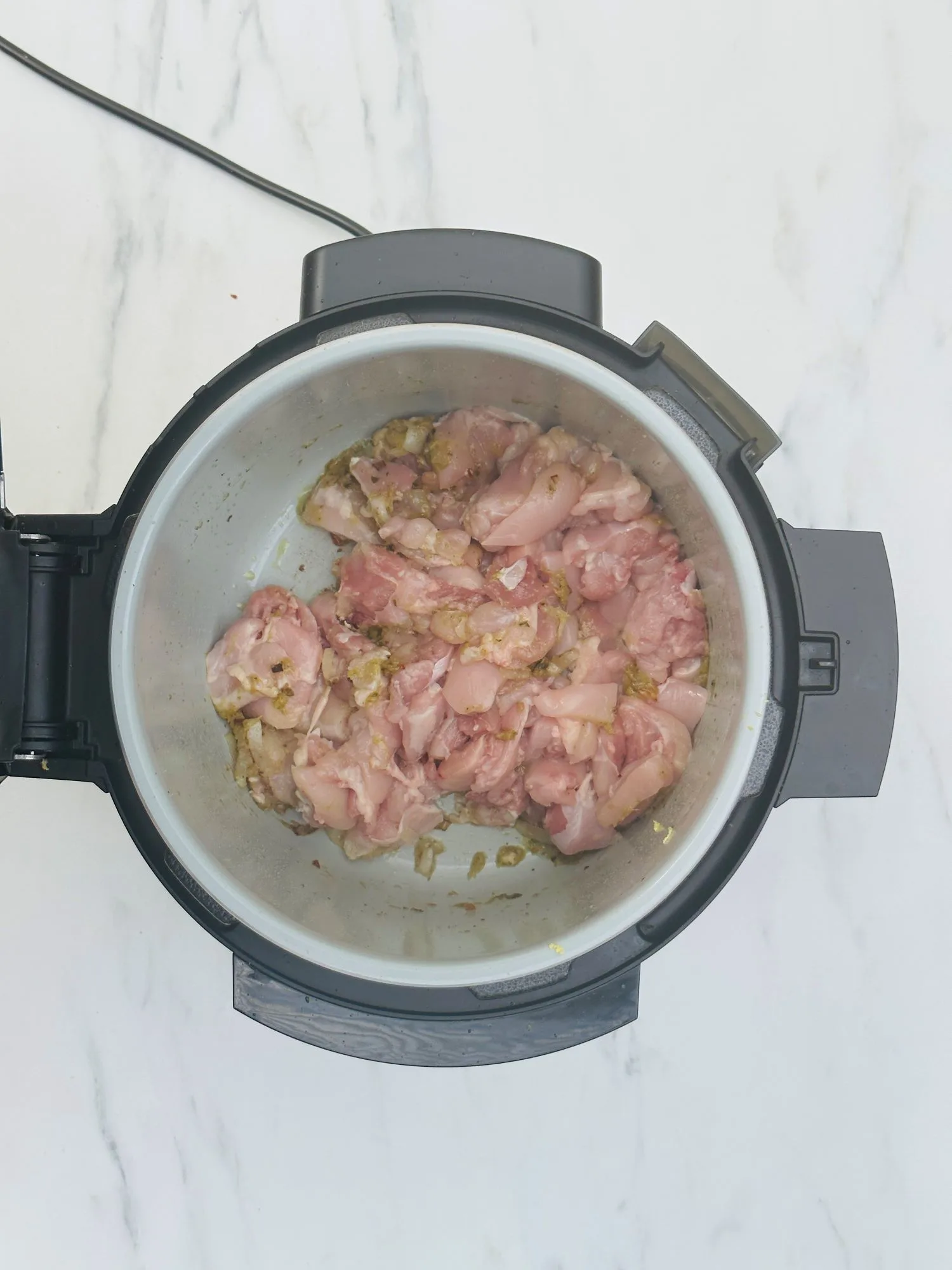 adding chicken to Ninja Foodi pressure cooker