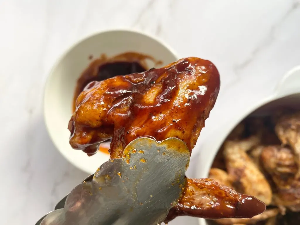 air fryer chicken wing dipped in BBQ sauce