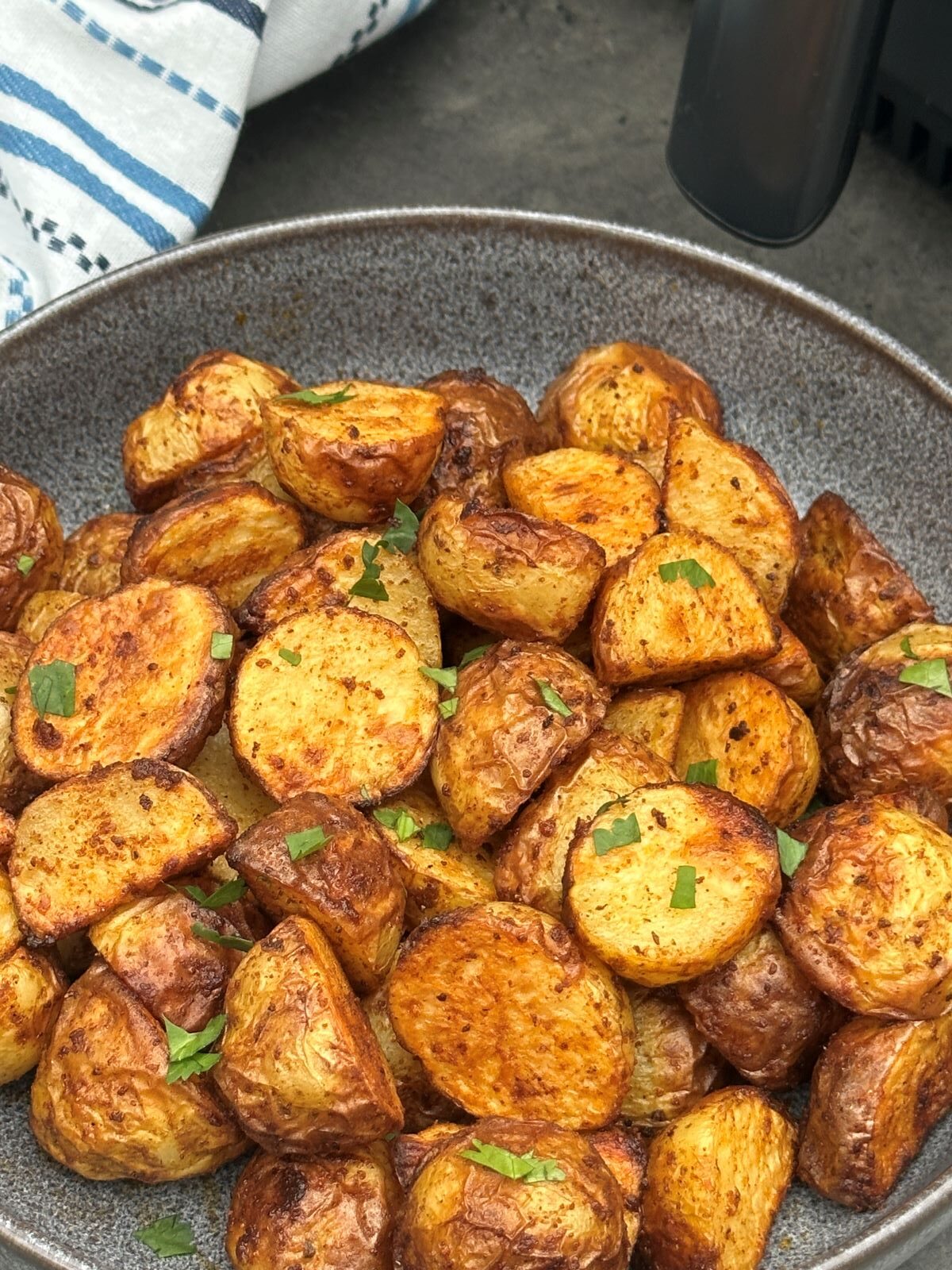 air fryer roasted new potatoes with fresh coriander herbs sprinkled on top