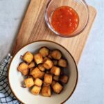 air fryer tofu in a bowl with sweet chilli dip next to it