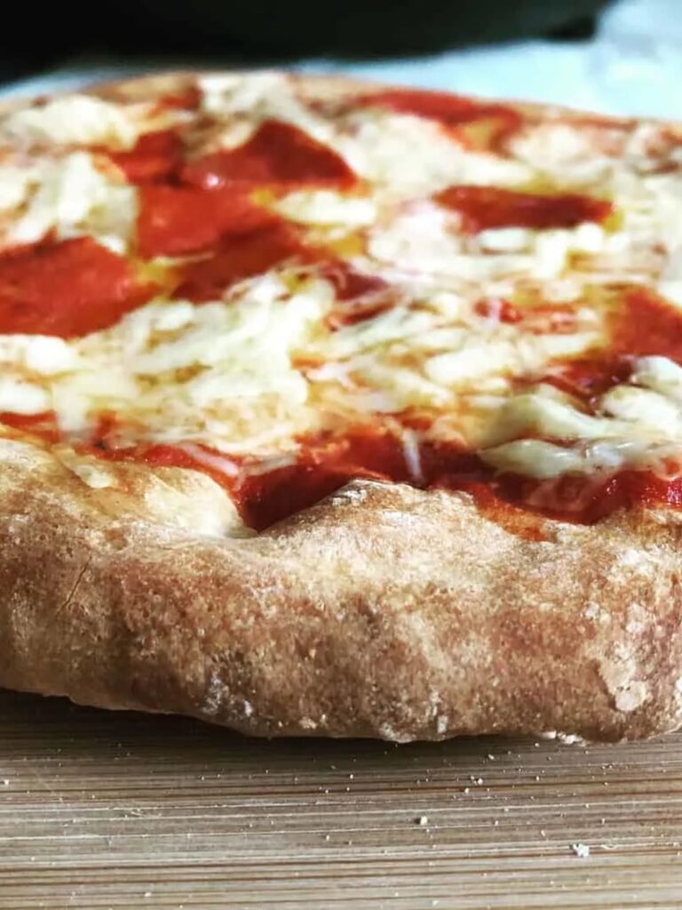 pizza cooked showing the crust cooked up close with melted cheese and pepperoni on top