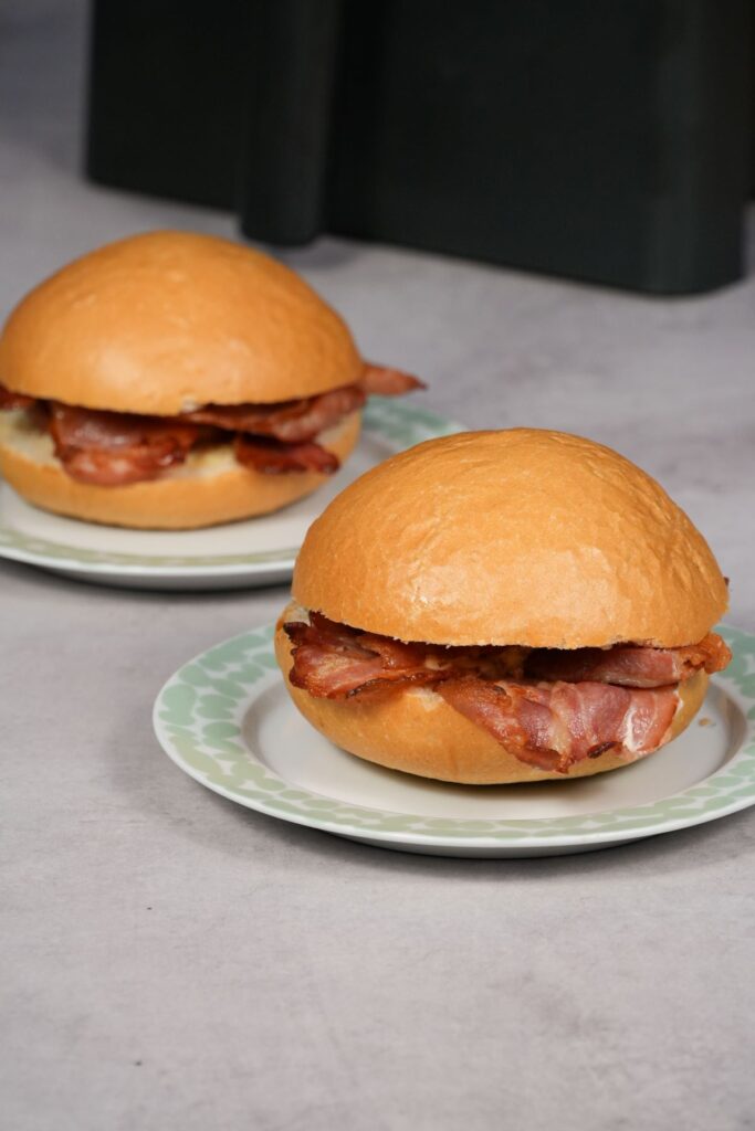 two bacon rolls next to an air fryer
