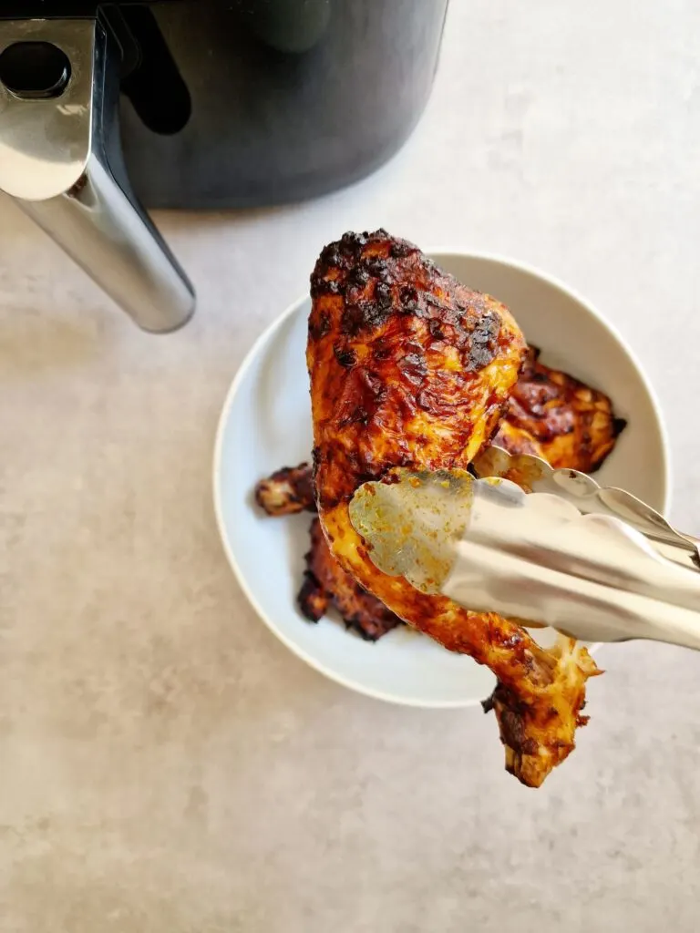 piri piri chicken leg next to air fryer