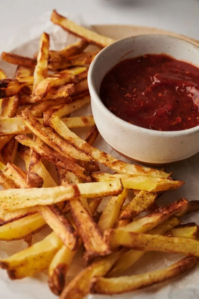 air fryer chips up close next to tomato ketchup sauce