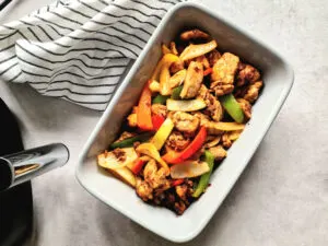 air fryer fajitas in bowl next to Proscenic Air Fryer