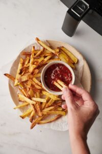 chips with ketchup next to an air fryer