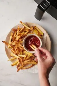 chips with ketchup next to an air fryer