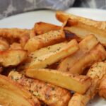roasted parsnips on a plate with dried herbs sprinkled on top