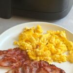 air fryer scrambled eggs with bacon on plate