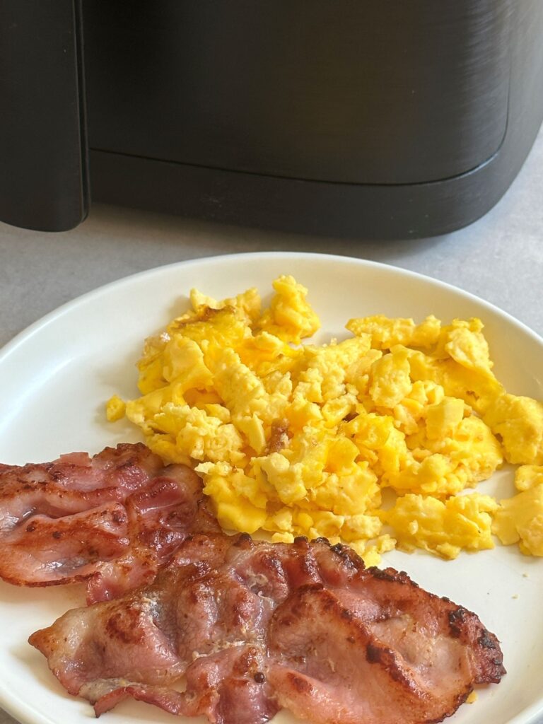 air fryer scrambled eggs with bacon on plate